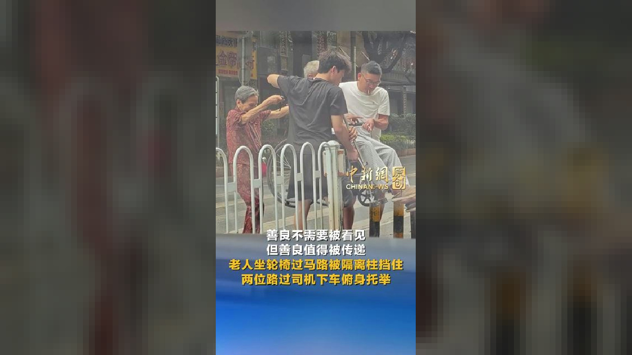 老人坐轮椅过马路被隔离柱挡住 两位路过司机下车俯身托举